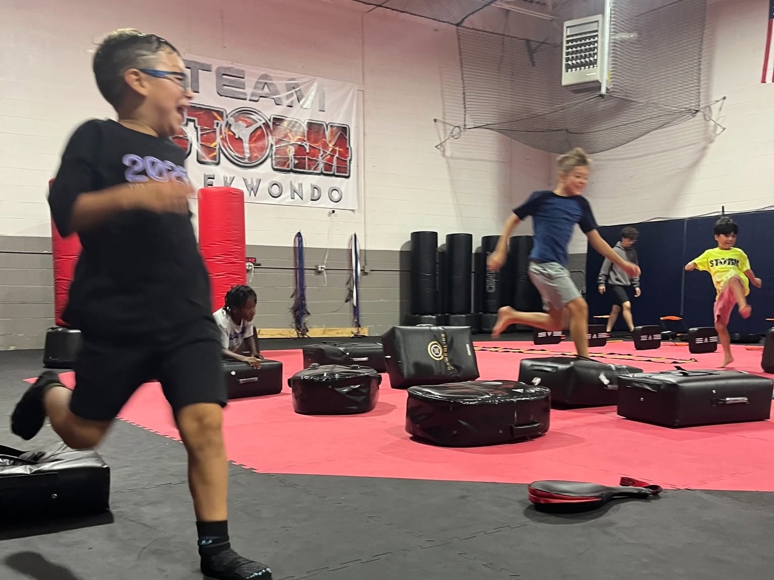 Storm students in athletic clothing practicing agility around training pads