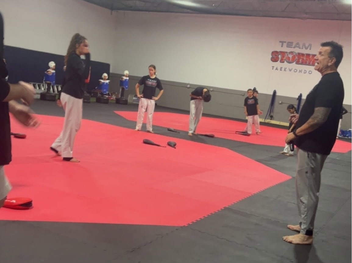 Storm instructor guiding students through basic movement on the training mats