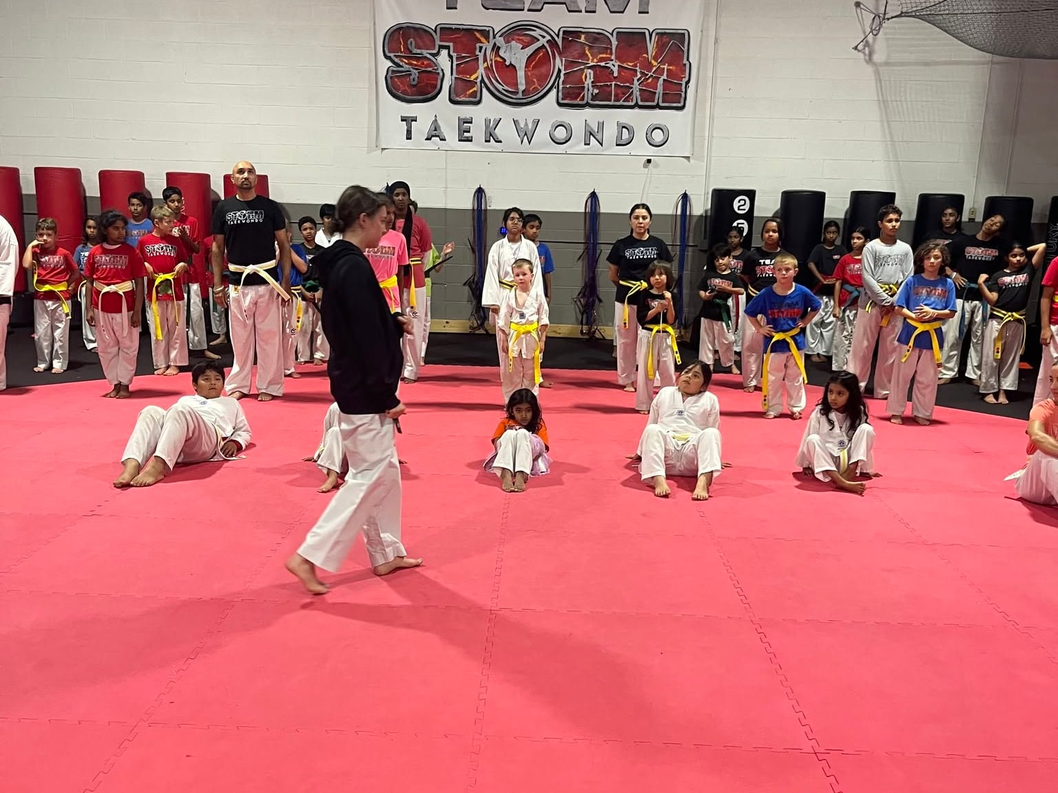 Storm instructor leading students through a floor exercise during class