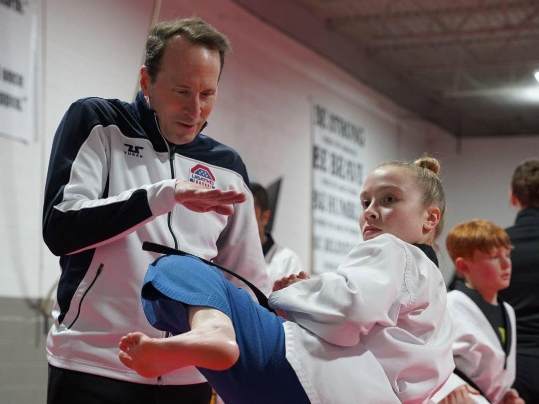 Storm instructor helping a young student refine a controlled kick