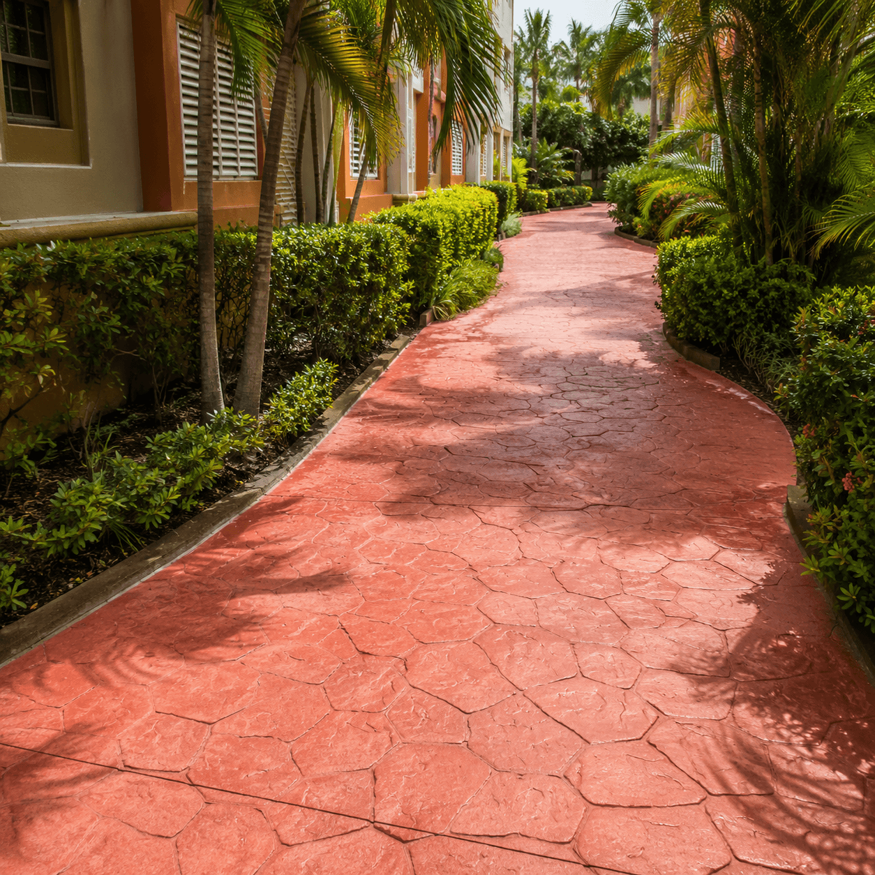 Pasillo de condominio con piso de concreto existente renovado con overlay estampado rojo de 3mm a 6mm sin demolición