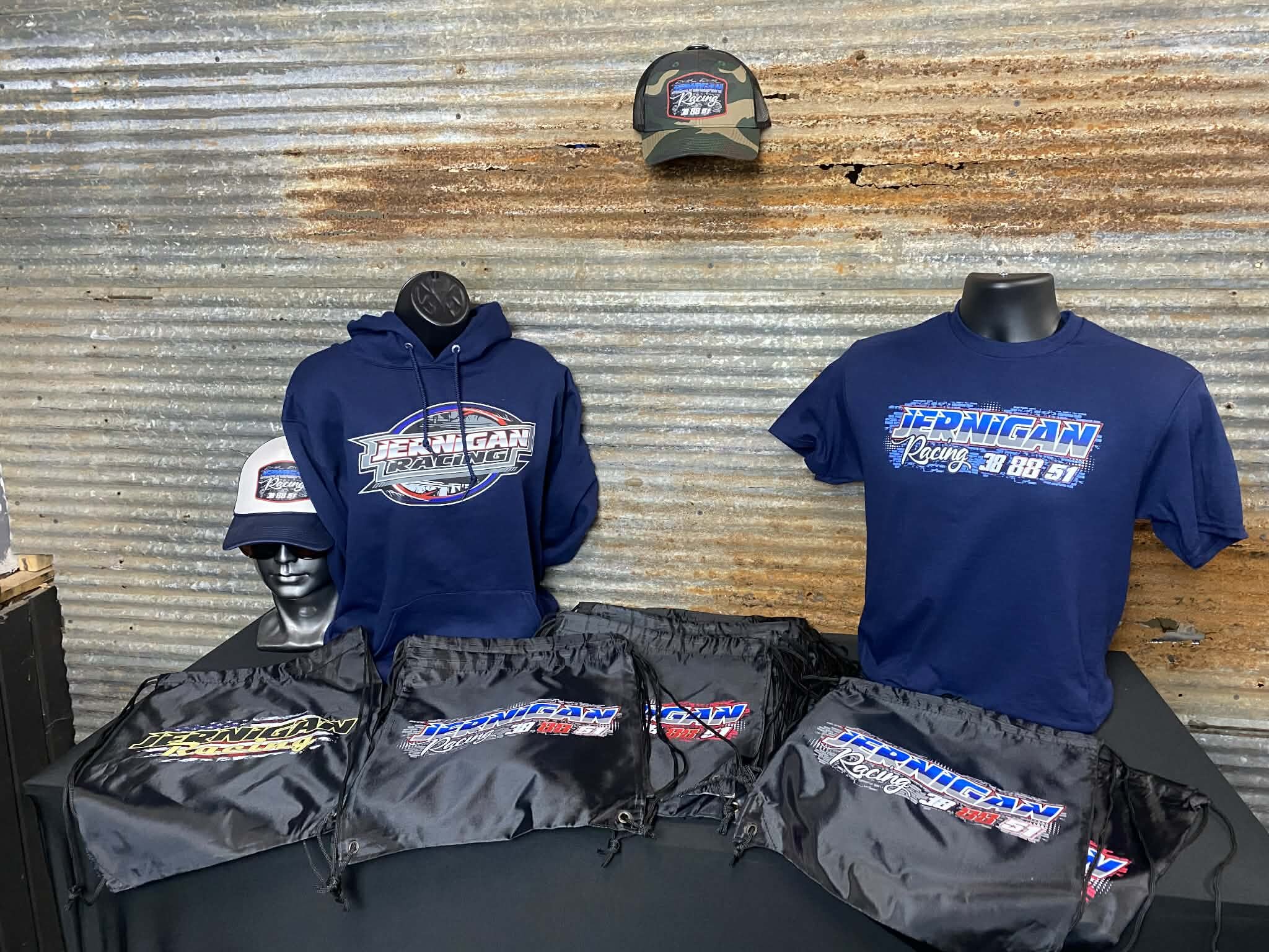 Custom printed Jernigan Racing team apparel — hoodie, t-shirt, hats, and bags